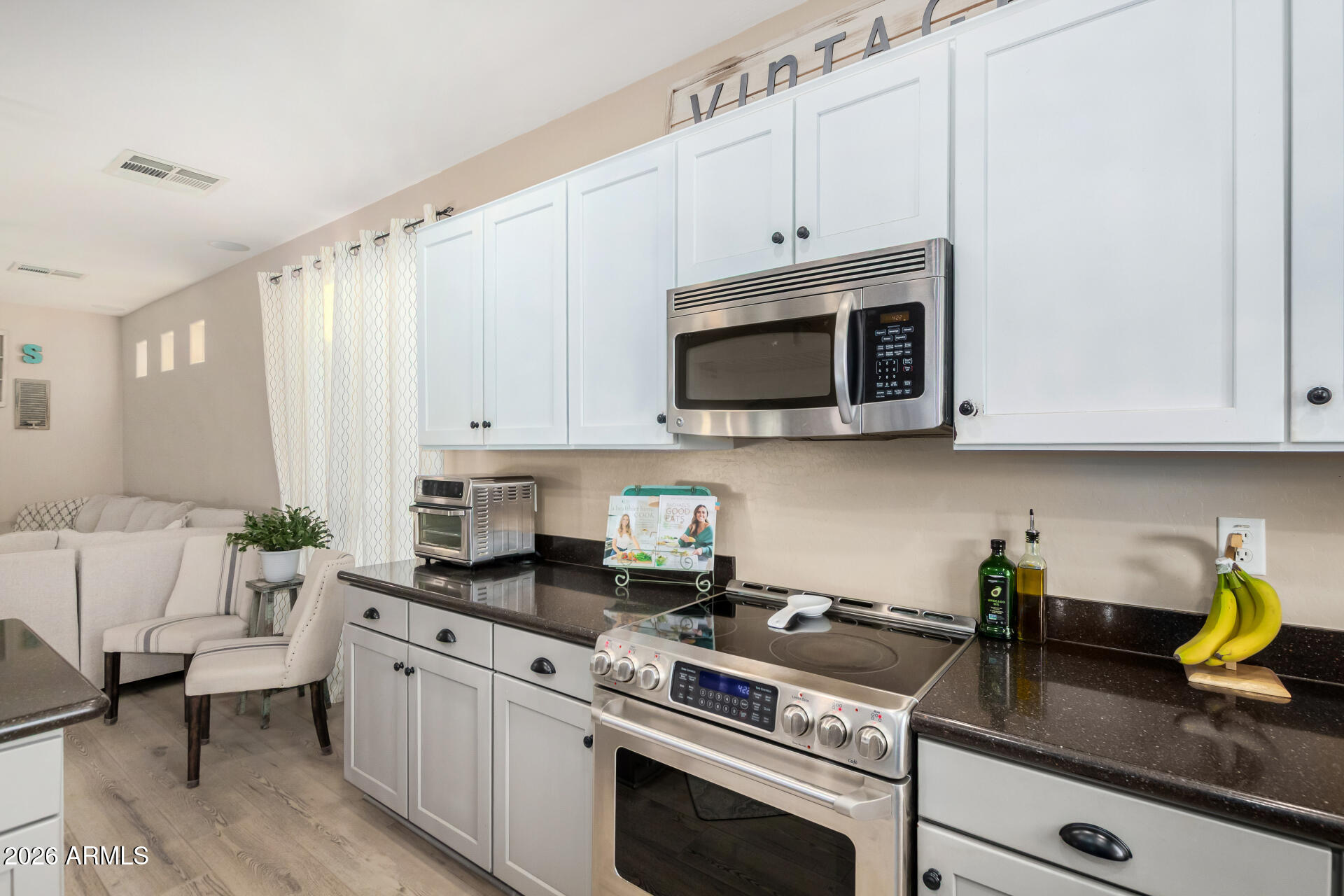 7316 West Montgomery Road Peoria, AZ 85383 - Photo 14 of 49 a kitchen with stainless steel appliances granite countertop white cabinets a stove top oven a sink and dishwasher