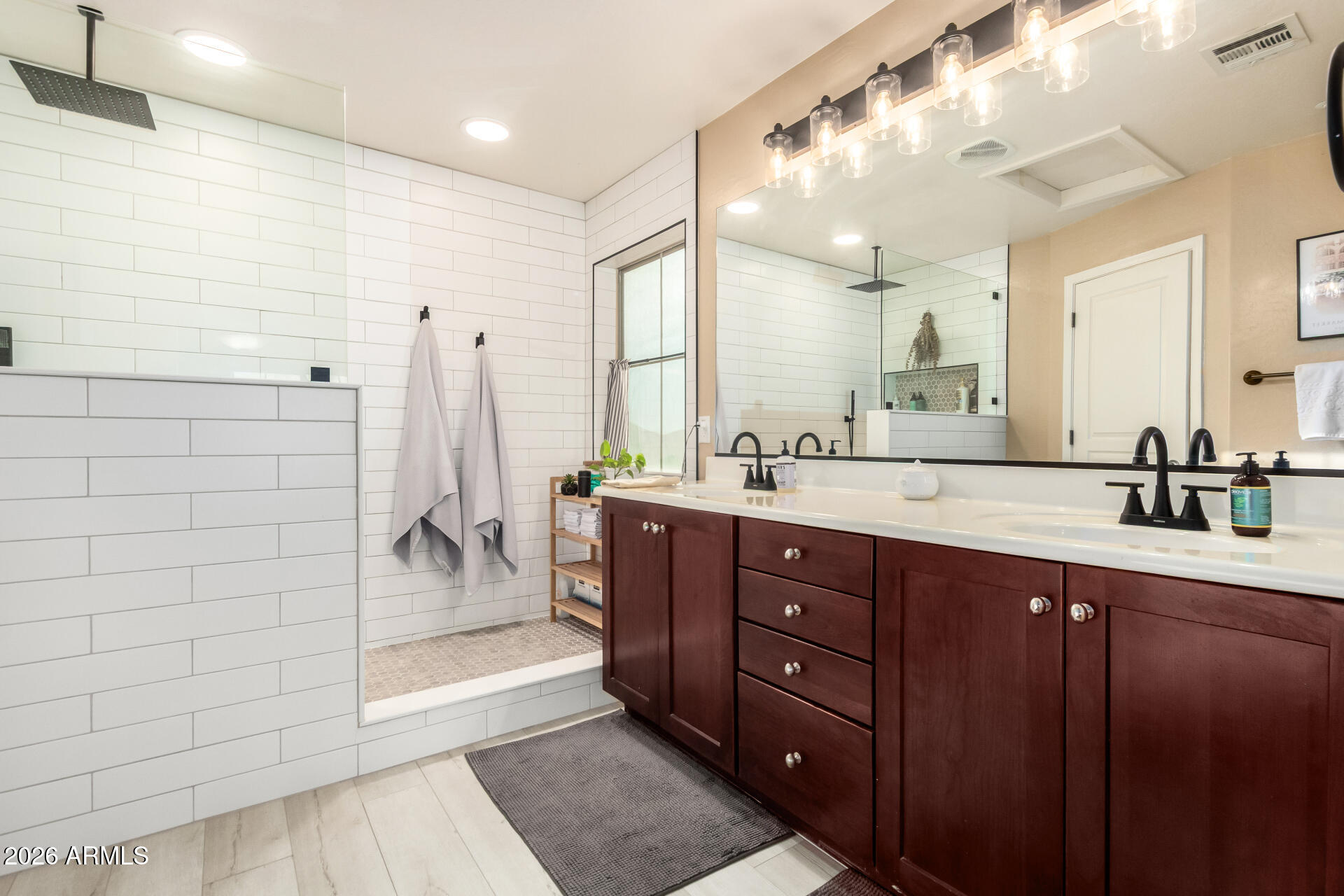 7316 West Montgomery Road Peoria, AZ 85383 - Photo 27 of 49 a bathroom with a double vanity sink a large mirror and shower