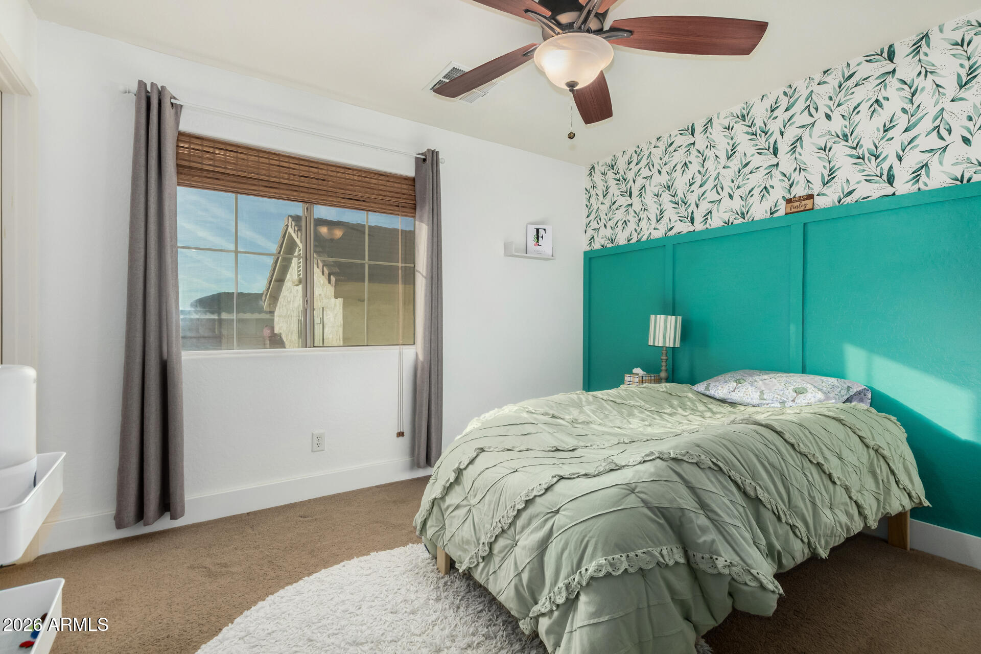 7316 West Montgomery Road Peoria, AZ 85383 - Photo 30 of 49 a bed sitting in a bedroom next to a window