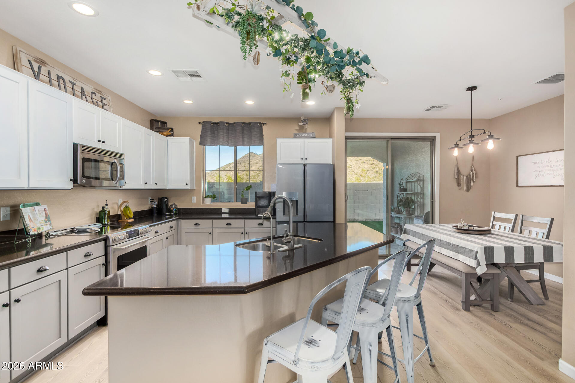 7316 West Montgomery Road Peoria, AZ 85383 - Photo 10 of 49 a large kitchen with granite countertop lots of counter space white cabinets and stainless steel appliances