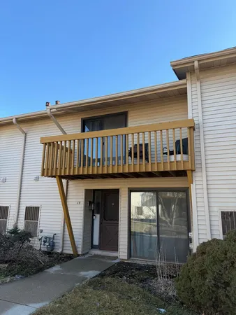 a view of a house with large windows and a small yard