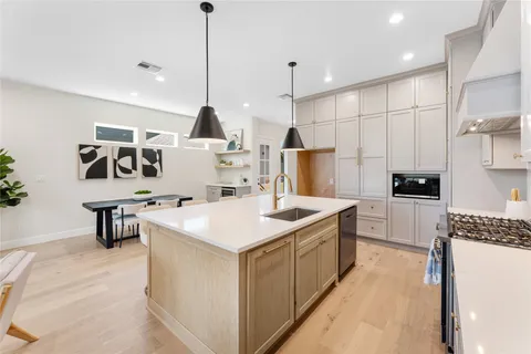 a kitchen that has a counter a sink a stove and a refrigerator