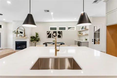 a view of kitchen with kitchen island a sink a stove and a refrigerator