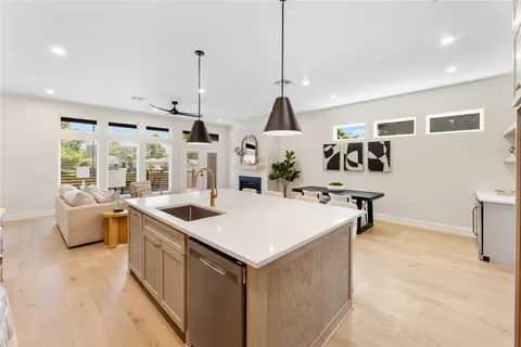 a open kitchen with stainless steel appliances granite countertop a sink a counter top space and living room view