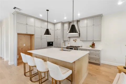 a kitchen with a table a sink and cabinets