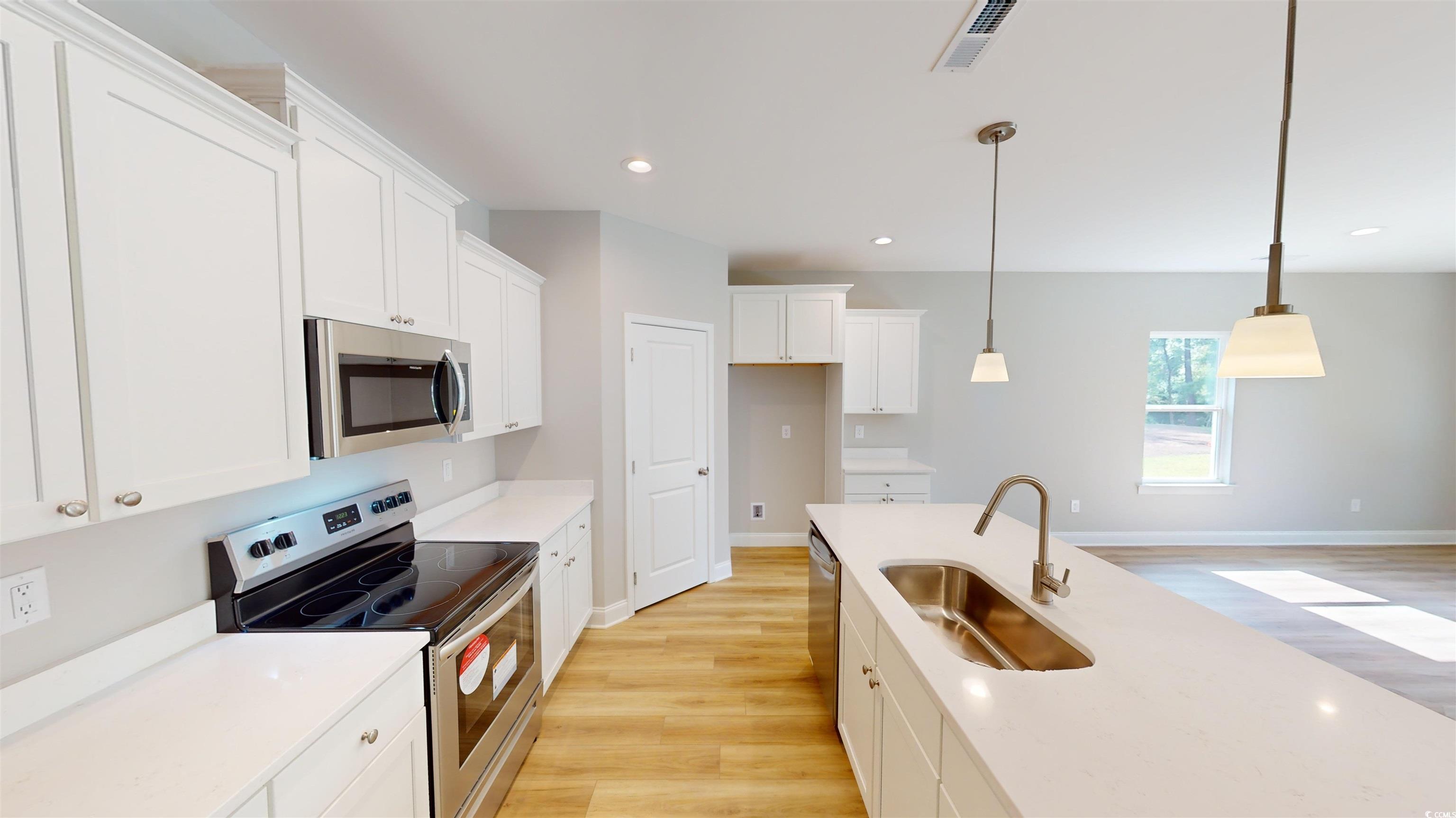 1016 Moen Loop, Unit LOT 5 Conway, SC 29526 - Photo 16 of 31 Kitchen with appliances with stainless steel finishes, light wood-style flooring, white cabinetry, decorative light fixtures, and light countertops