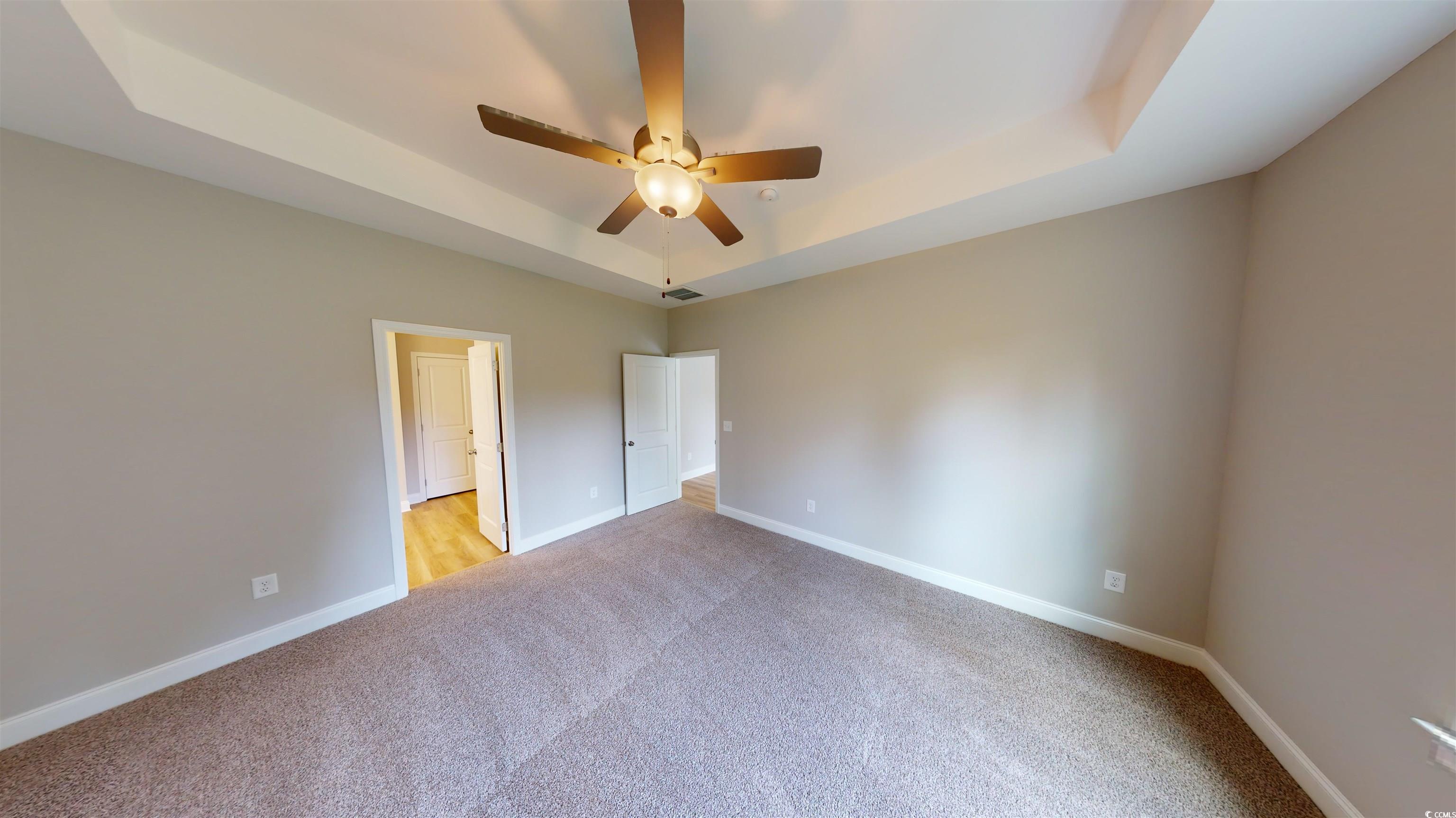 1016 Moen Loop, Unit LOT 5 Conway, SC 29526 - Photo 19 of 31 Unfurnished bedroom with a raised ceiling, light colored carpet, and a ceiling fan