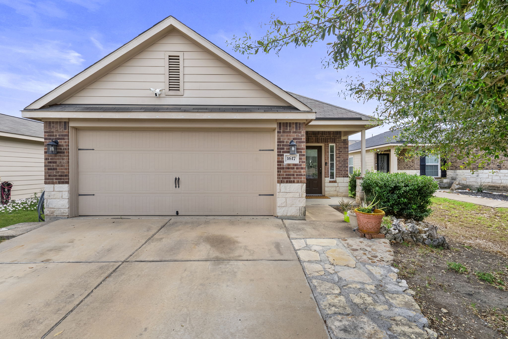 1617 Treeta Trail Kyle, TX 78640 - Photo 1 of 39 Ranch-style home featuring brick siding, concrete driveway, and an attached garage