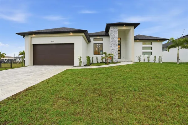 a view of a house with a yard and garage