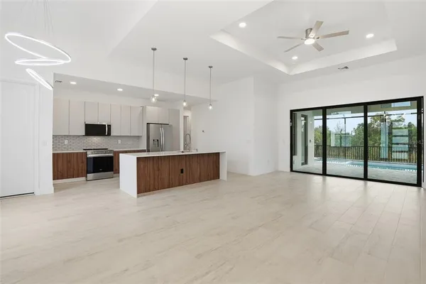 a large kitchen with stainless steel appliances kitchen island a large counter top a sink a stove and a refrigerator