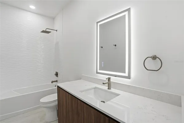 a bathroom with a sink a toilet and mirror