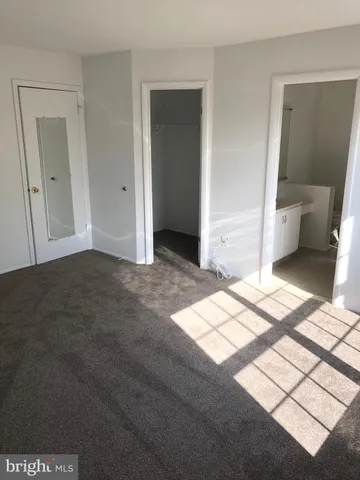 a view of a bedroom with wooden floor and a bathroom space