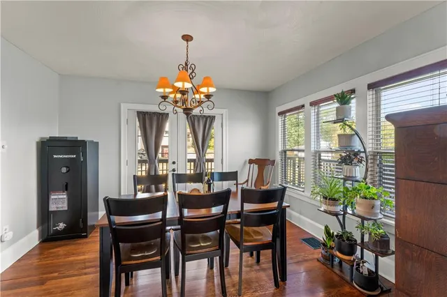 a dining room with furniture a chandelier and wooden floor