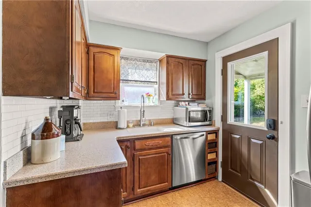 a kitchen with stainless steel appliances granite countertop a sink a stove and a refrigerator