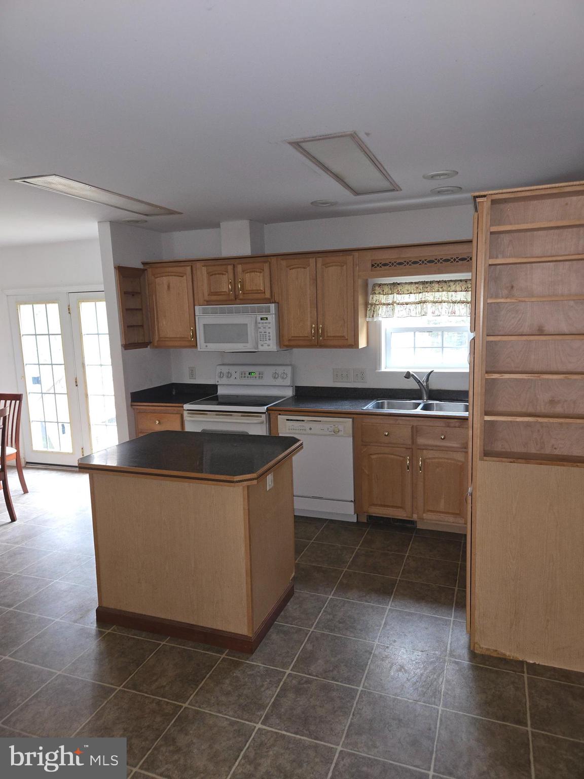 30921 Johnson Road Salisbury, MD 21804 - Photo 4 of 11 a kitchen with stainless steel appliances a sink a stove a microwave and cabinets