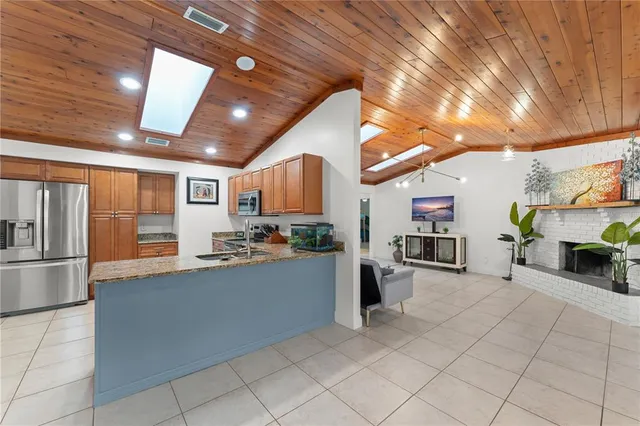 a large white kitchen with lots of counter top space and stainless steel appliances