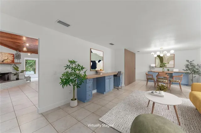 a living room with furniture a potted plant and a table