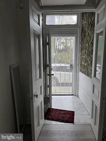 a view of a hallway with wooden floor and stairs