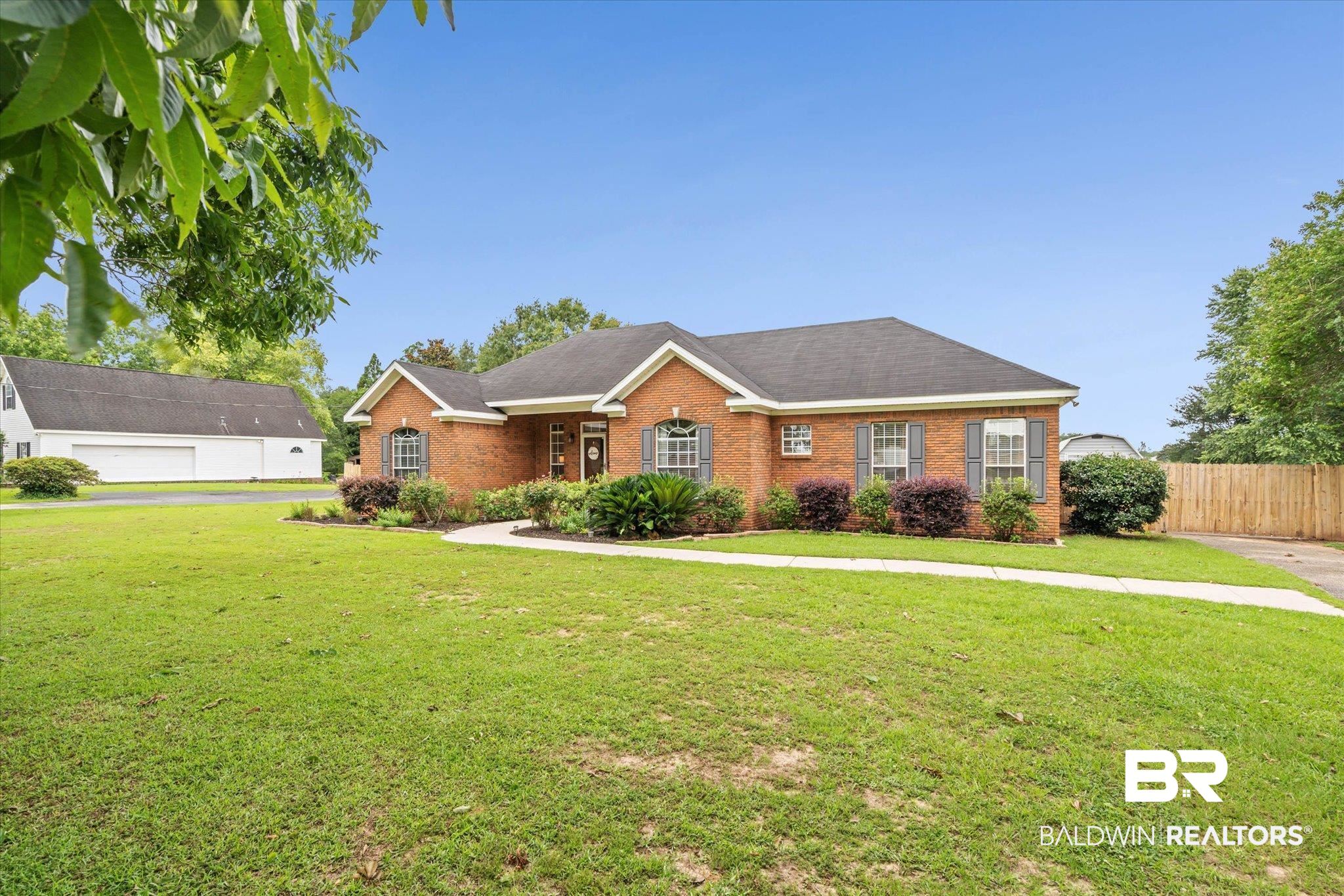 3170 Scott Dairy Loop Road West Mobile, AL 36695 - Photo 22 of 24 Traditional brick home featuring a dark shingle roof, decorative shutters, and established landscaping