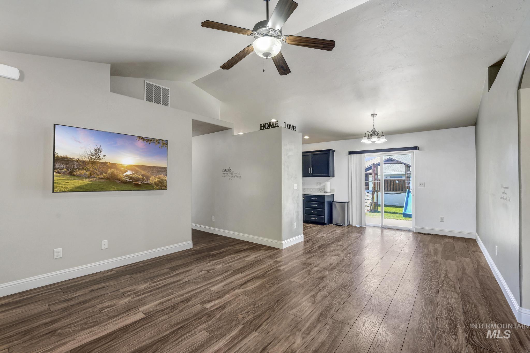 446 Noble Street Twin Falls, ID 83301 - Photo 5 of 42 Spacious living area featuring vaulted ceilings, wood-finish flooring, a ceiling fan, and sliding glass doors providing access to the exterior