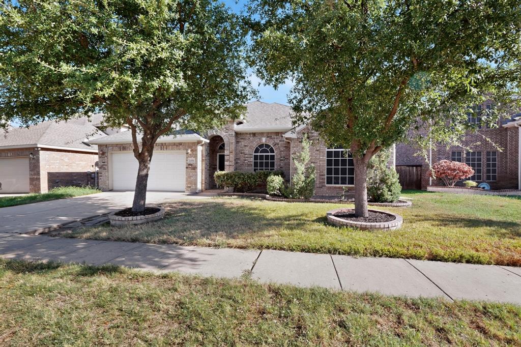 14908 Riverside Drive Little Elm, TX 75068 - Photo 2 of 40 Brick exterior with arched entry, dual garage doors, arched windows, and mature trees