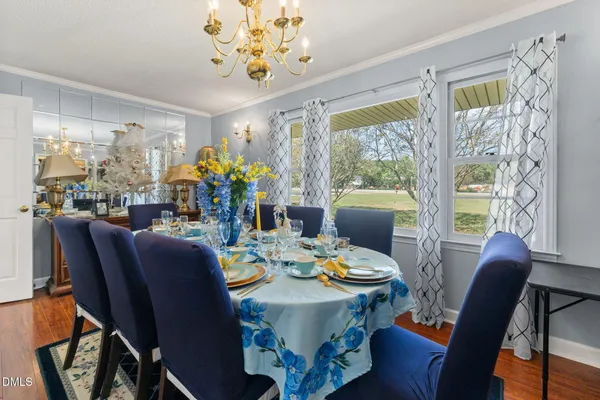 a view of a dining room with furniture a chandelier and wooden floor