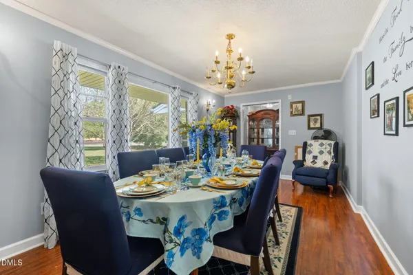 a view of a dining room with furniture a chandelier and wooden floor