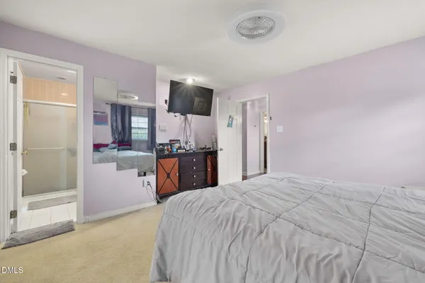 a large bedroom with a bed dresser and a large window