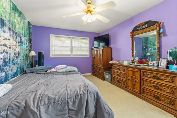 a bedroom with a bed and a dresser with mirror