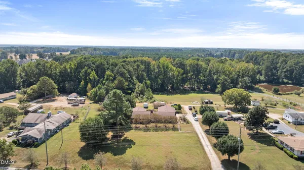 an aerial view of residential houses with outdoor space and trees