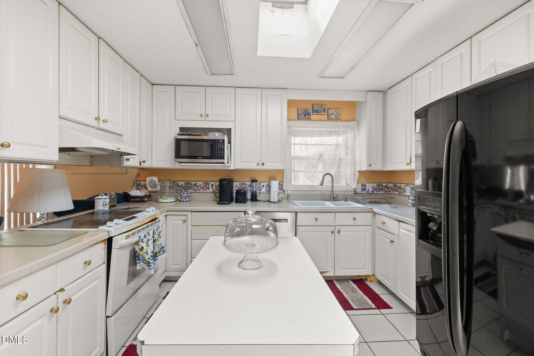 4017 Tryon Road Raleigh, NC 27606 - Photo 6 of 39 a kitchen with a stove a sink and a refrigerator