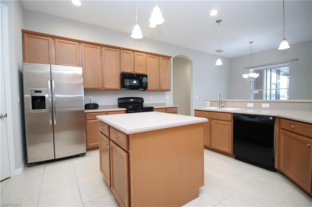 2086 Grove Drive Naples, FL 34120 - Photo 12 of 24 a kitchen with a sink a refrigerator and cabinets