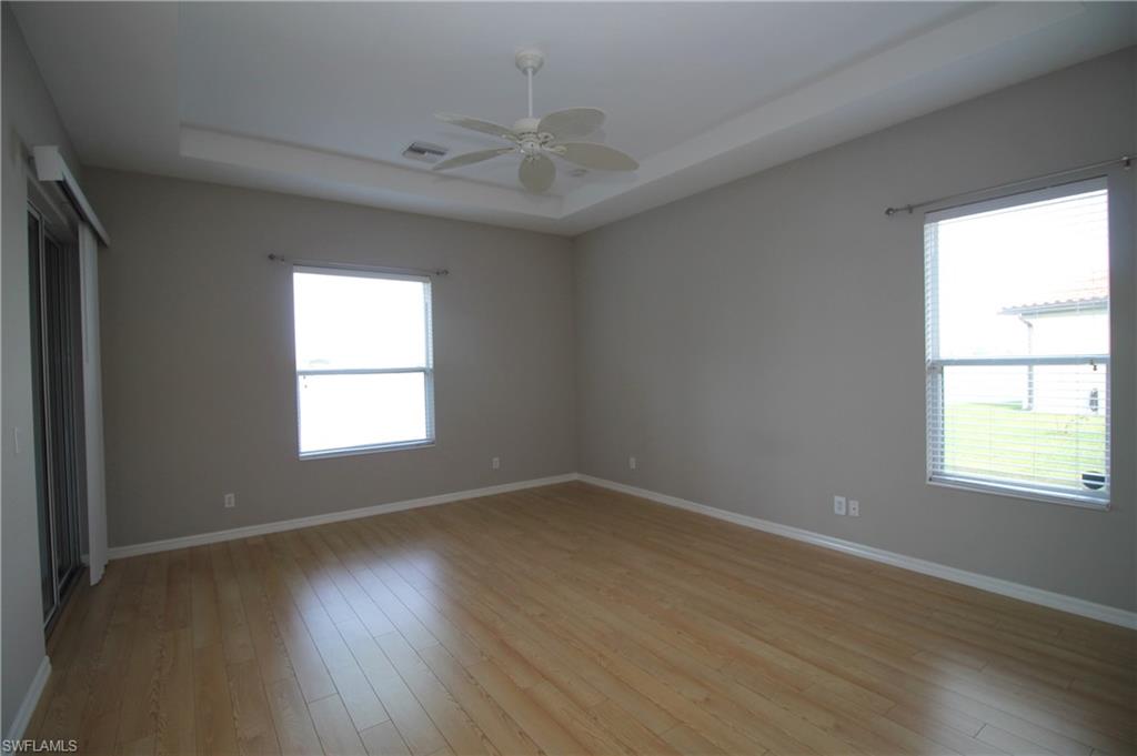2086 Grove Drive Naples, FL 34120 - Photo 14 of 24 an empty room with wooden floor and windows