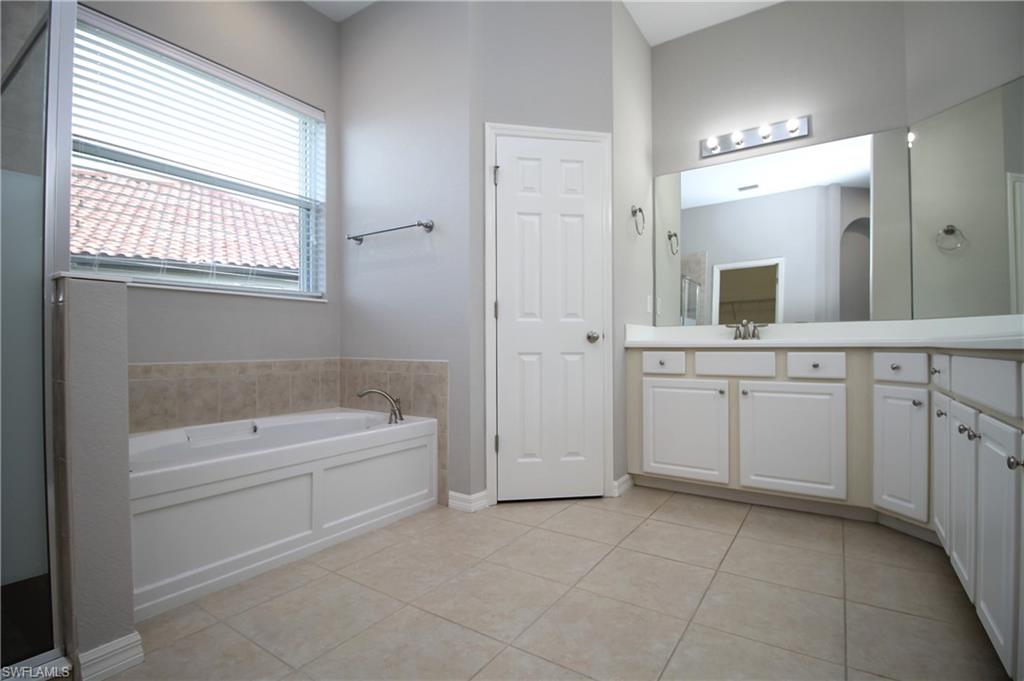 2086 Grove Drive Naples, FL 34120 - Photo 17 of 24 a spacious bathroom with a tub sink and mirror