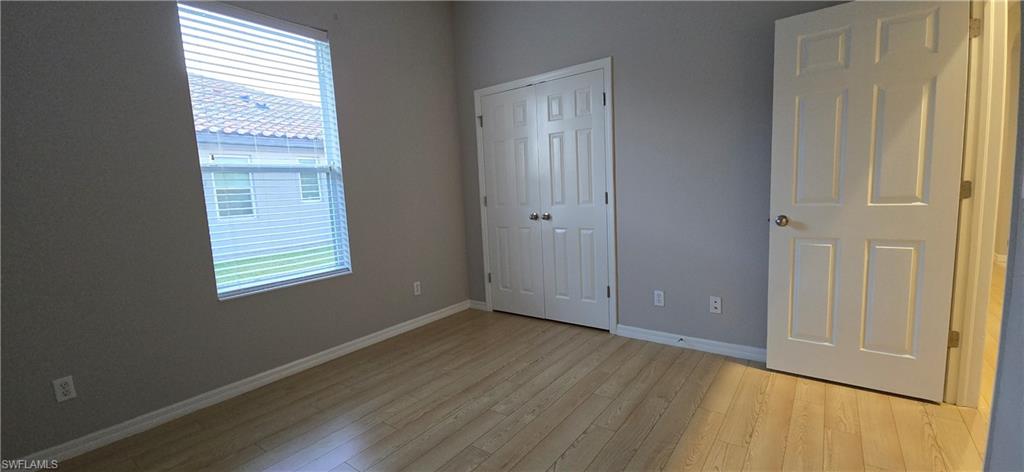 2086 Grove Drive Naples, FL 34120 - Photo 19 of 24 a view of an empty room with wooden floor and a window