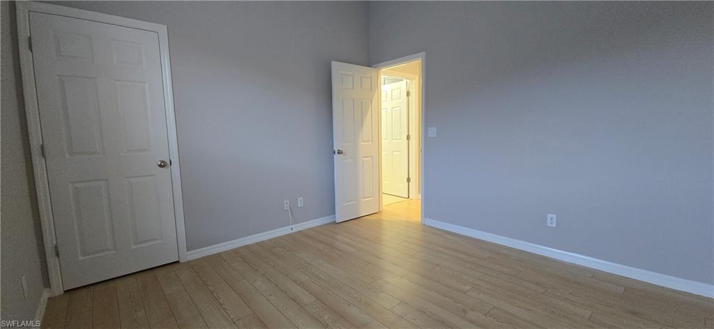2086 Grove Drive Naples, FL 34120 - Photo 21 of 24 a view of an empty room with wooden floor and a window