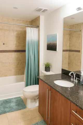 a bathroom with a granite countertop sink mirror vanity and toilet