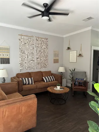 a living room with furniture and a wooden floor