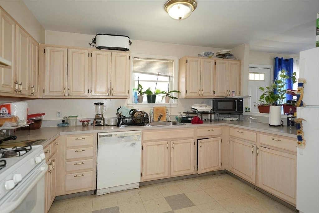 103 Devon Street Boston, MA 02121 - Photo 20 of 28 a kitchen with white cabinets sink and window