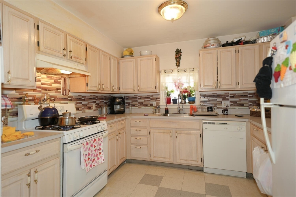 103 Devon Street Boston, MA 02121 - Photo 8 of 28 a kitchen with cabinets appliances a sink and a counter top space