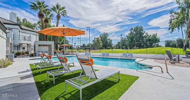 a view of a chairs and table in the patio with a swimming pool