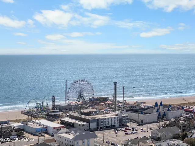 a view of a white house with large windows and a small yard