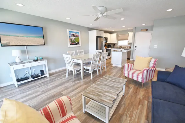 a living room with furniture wooden floor and a flat screen tv