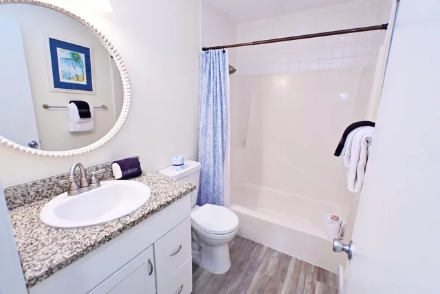 a bathroom with a granite countertop sink toilet and shower