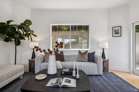 a living room with furniture kitchen view and large windows