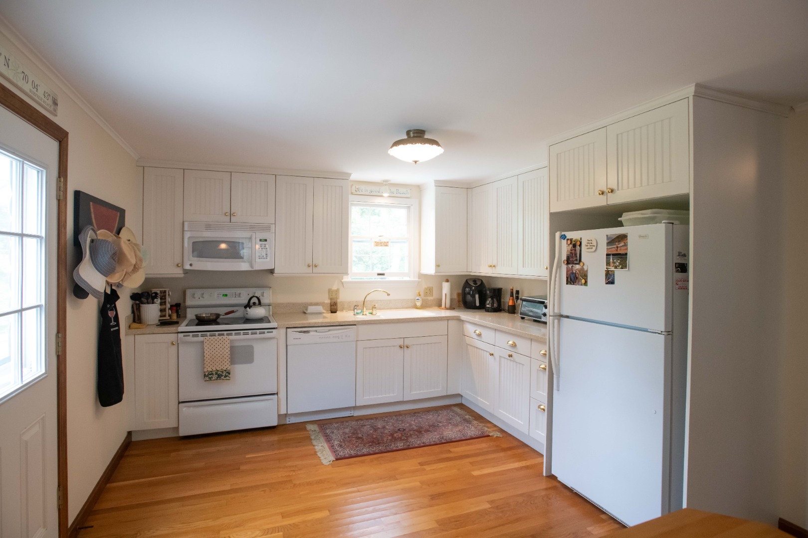 134 Surfside Road Nantucket, MA 02554 - Photo 14 of 24 a kitchen with white cabinets and white appliances