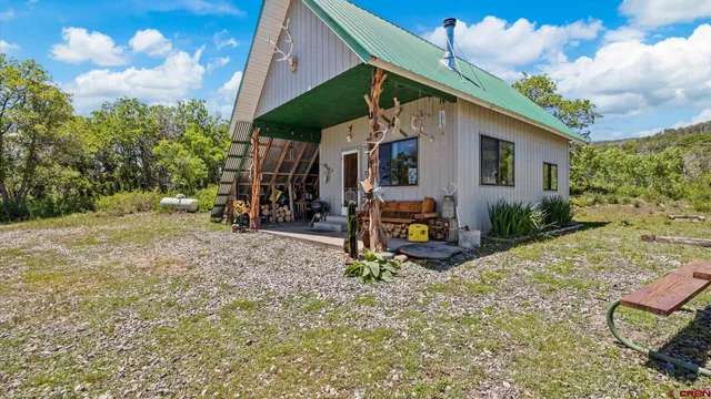 a view of a chair and table in backyard of the house