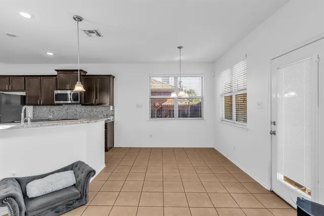 a kitchen with stainless steel appliances kitchen island granite countertop a sink refrigerator and cabinets