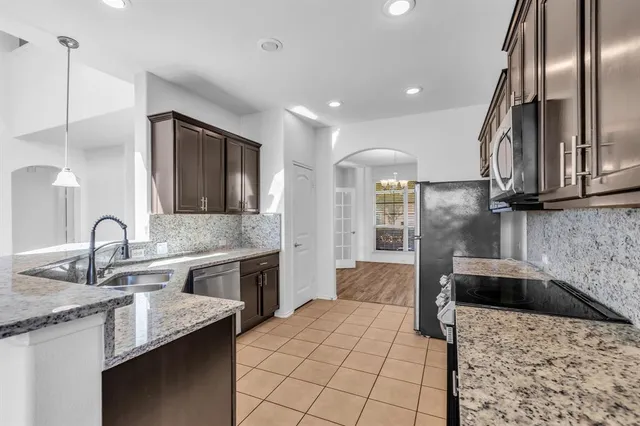 a kitchen with stainless steel appliances granite countertop a sink stove and microwave