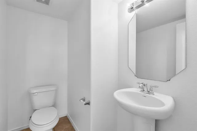 a view of a big room with chandelier fan and windows